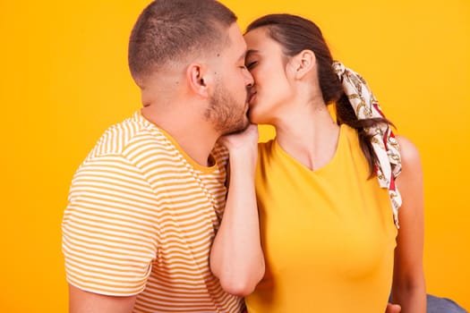 Close up of beautiful girlfriend kissing her boyfriend in studio. Romantic couple.