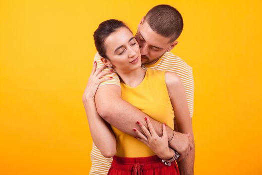 Girlfriend holding eyes closed while boyfriend hugs her from behind. Couple in love.