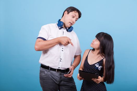 Caucasian boyfriend pointing at table and asian girlfiend looking at him. Interracial couple.