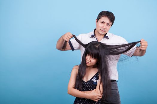 Caucasian boyfriend playing with his asian girlfriend long hair. Interracial couple.