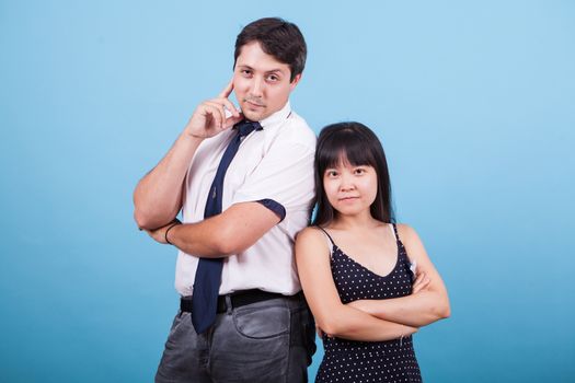 Cheerful young interracial couple looking at the camera in studio. Asian girlfriend.