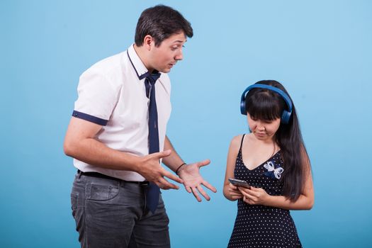 Asian girlfriend ignoring her caucasian boyfriend while he's trying to speak with her. Interracial couple.