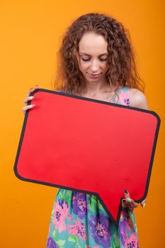 Portrait of young woman looking down on a empty placard. Copy space available.