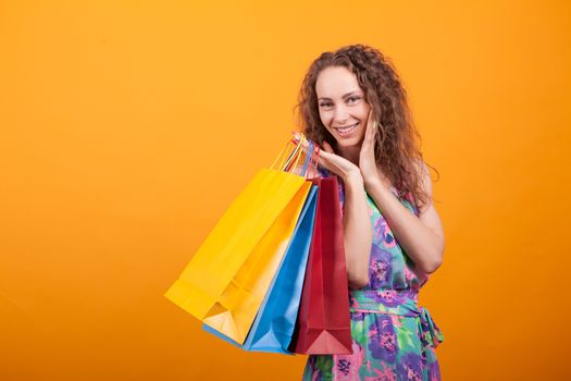 Gorgeous and shopaholic woman holding shopping bags. Cheerful and stylish woman.