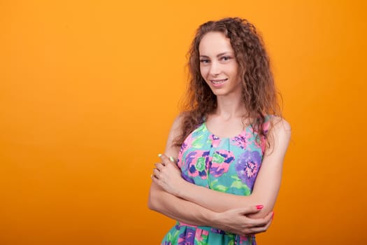 Portrait of beautiful woman with a big and natural smile in studio. Crossed arms.