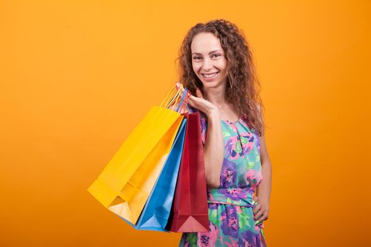 Attractive woman in pretty dress holding shopping bags. Fancy lifestyle.