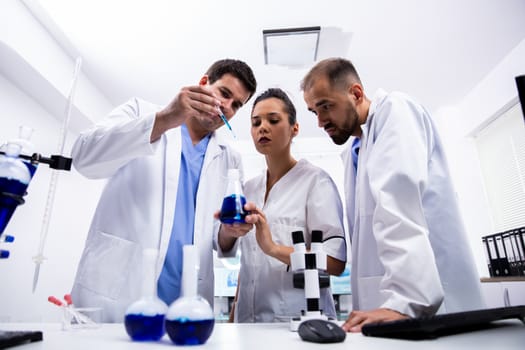 Team of researchers in white coat having a brainstorm. Modern laboratory