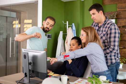 Worker of start-up company having a discussion in front of computer screen