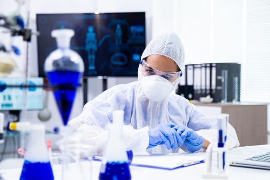 Scientist is looking at some blue specimens on the table. Pharmaceutical research