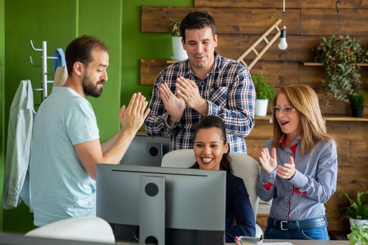 Celebrating a successful partnership in modern start-up company office