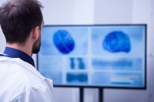 Young male doctor checking his patient brain after surgery. Doctor in hospital.