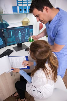 Young scientist man working together with female microbiologist in a research lab