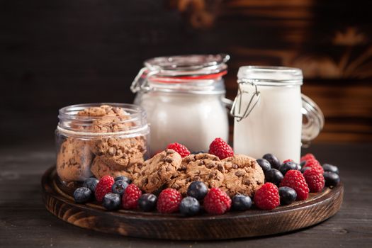 Food composition of tasty and delicious chocolate chips with fresh milk. Delicious raspberries.