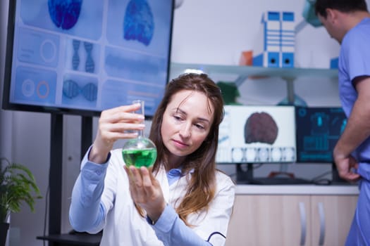 Mature female scientist in a factory research lab for plant research. Male scientist in the background.