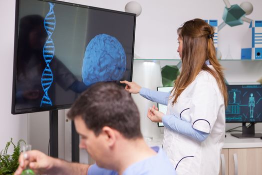 Research scientist pointing at monitor in a research lab for human health. Brain analysis.