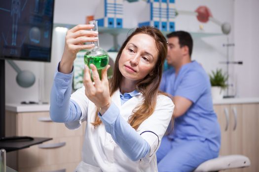 Middle age scientist doing research on plants for agriculture industy. Female scientist holding a test tube.