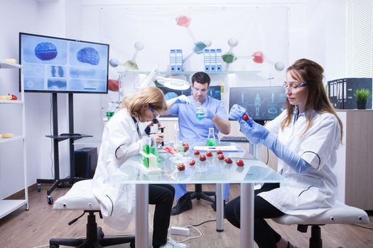 Groupe of three scientist working in a research lab for product analysis. Microbiology analysis.