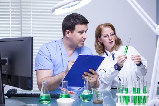 Scientists in biotechnology checking the solution from a test tube. Scientific test.