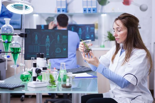 Female scientist with a microscope on her research lab. Test tubes.