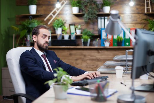 Serious young entrepreneur working on computer in his office. Focused manager.