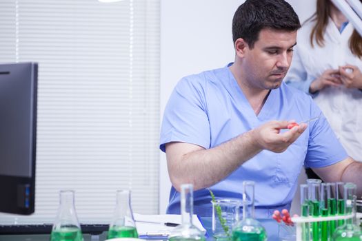 Young caucasian scientist man using a pipette to take a sample of solution in a factory lab research. Production lab.