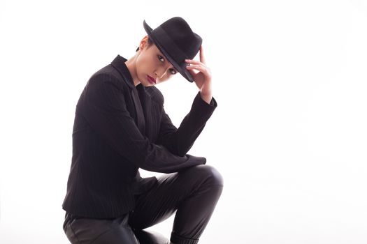 Attractive caucasian female with a stylish hat posing in studio over a white background. Fashion model.