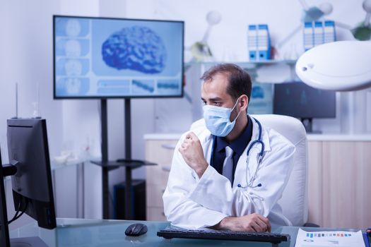 Concentrating doctor on his work at the cabing with his mout covered. Doctor with protection mask.
