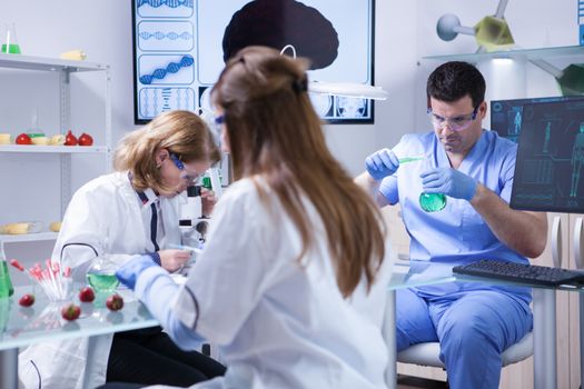 Caucasian scientist working with solutions for biotechnology. Team of scientist.