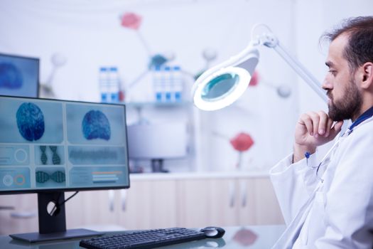 Young bearded doctor doing a brain examination in a modern hospital. Radiologist in a hospital laboratory.