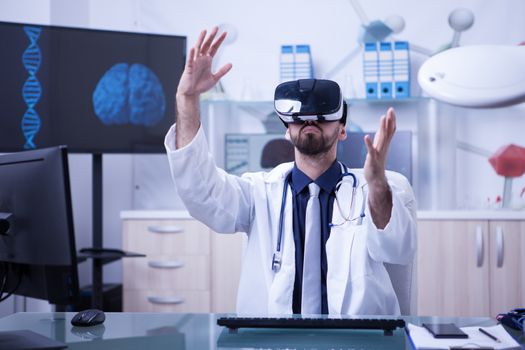 Smart doctor wearing virtual reality goggles in modern clinic office. Doctor with stethoscope.