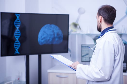 Doctor in his cabinet looking at a braind and trying to put a diagnosis. Doctor giving his expertise.