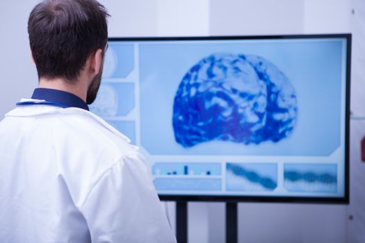 Male doctor in hospital explores the tomography brain on the monitor. Doctor checking the patient braind after a ct scan.