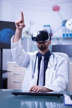 Young male doctor with virtual reality headset pointing. Future technology in hospitals.