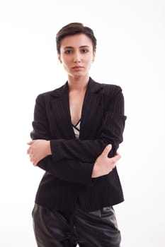 Beautiful young girl posing in front of the camera wearing a black jacket over white background. Attractive girl isolated over white background.