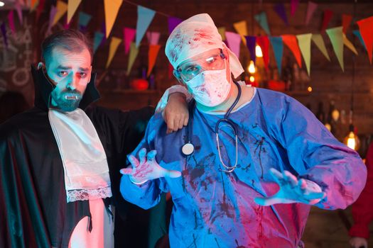 Handsome Dracula with his scary doctor friend at a halloween celebration. Handsome dracula.