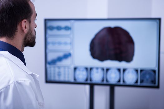 Handsome doctor analyzing a braing after a car accident. Doctor in hospital.