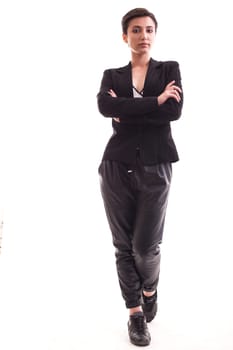 Full body photo of stylish girl posing in casual clothes in studio over white background. Girl with hands crossed wearing a black jacket.