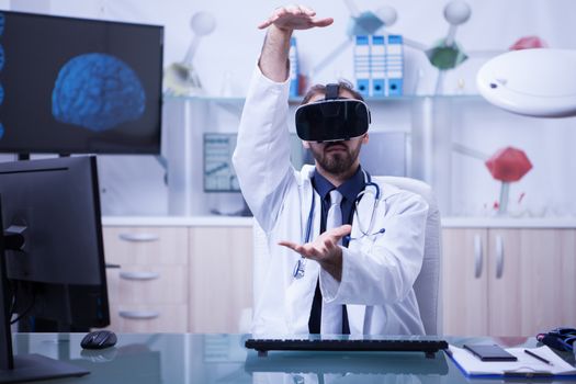 Doctor in his hospital office using virtual reality headset. Doctor with stethoscope around his neck.