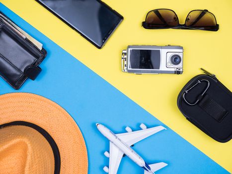 Flat lay top view of traveler kit for holiday over blue background. Traveler hat. Small traveler camera.