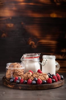 Freshly baked oatmeal biscuits with chocolate on wooden cutting board.