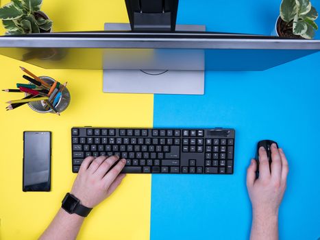 Flat lay top view of man sitting at his office typing on keyboard. Creative man working.
