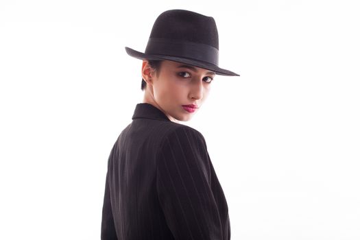 Portrait of glamorous young female posing in studio over white background. Stylish retro hat.