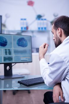 Ambitious doctor specialised in neurologic problems looking at the brain of a patient. Doctor at a brain clinic.