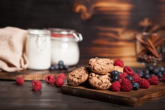 Tasty and delicious chocolate chips on wooden plate. Delicious blueberries.