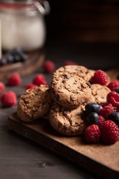 Delicious chocolate cookies for breakfast with milk and blueberries. Healthy biscuits.