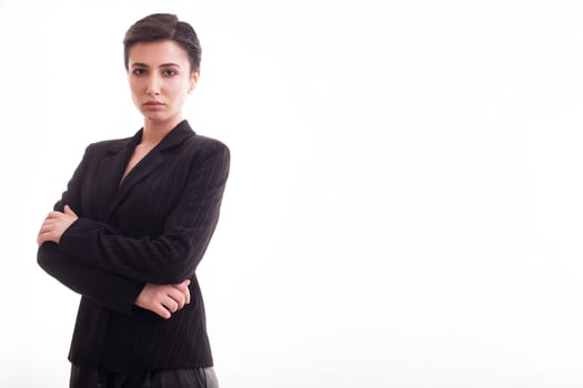 Beautiful and attractive young woman with hands crossed over white background wearing a black jacket. Copy space available.