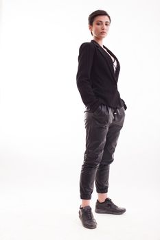 Beautiful young woman posing on white background in leather pants. Female model isolated on white background.