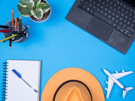 Flat lay top view of modern laptop over blue background. Traveler accessories.