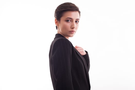 Side view portrait of beautiful young woman wearing a black jacket over white background. Caucasian beautiful woman in studio.