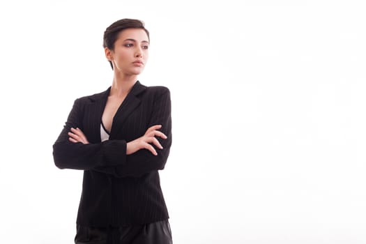 Beautiful young girl in black jacket with hands crossed looking away over white background. Copy space available. Modern outfit.